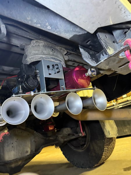 Four-trumpet train horn kit with HornBlasters compressor and pink air tank mounted under chassis