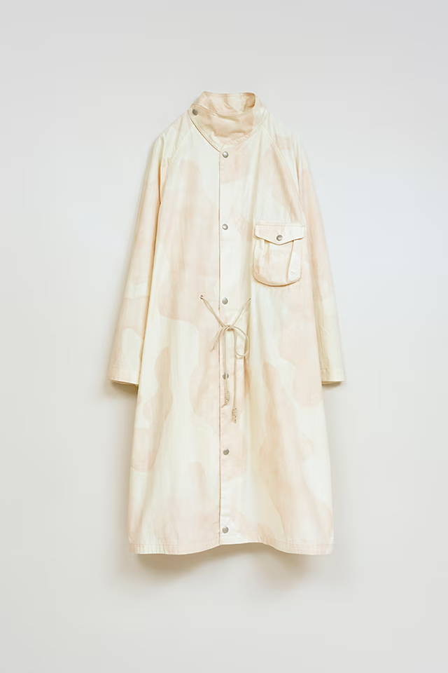 A cream-colored, long button-up shirt dress with a pocket.