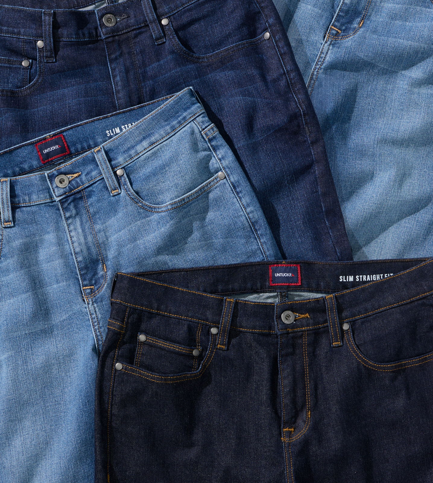 Various styles of denim jeans arranged together.