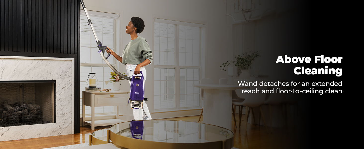 Person cleaning above a floor with a vacuum cleaner in a modern living room.