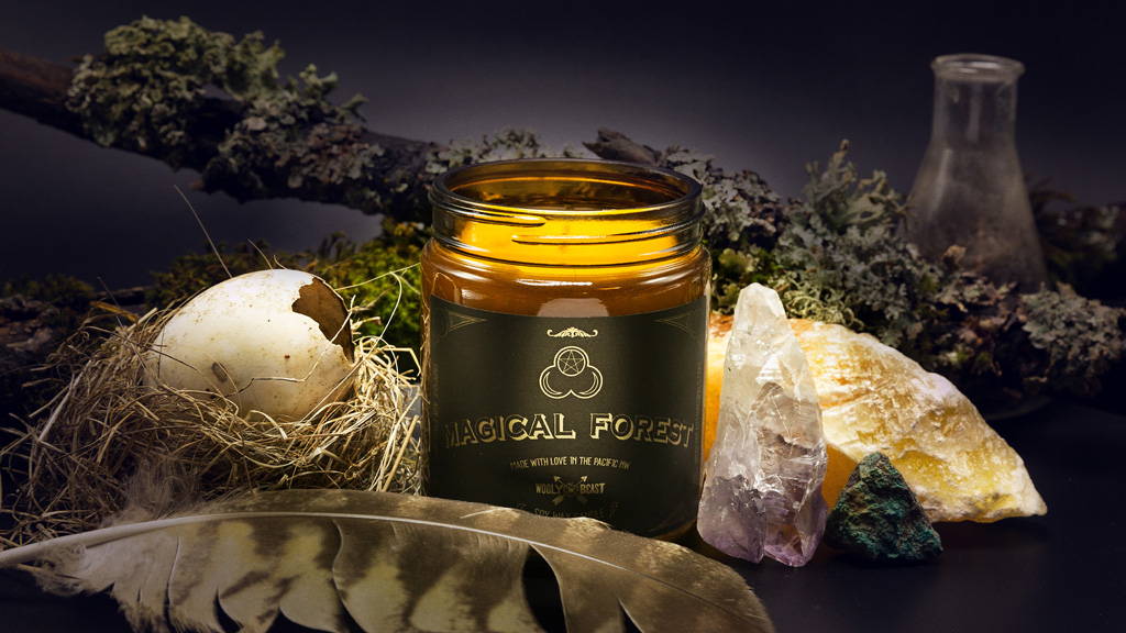 Magical Forest soy candle by Wooly Beast Naturals among crystals, broken bird egg, feather, moss, covered stick, goblin core theme