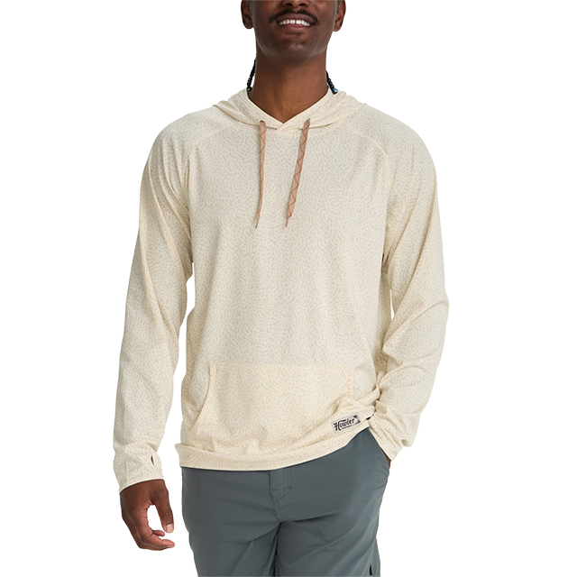 A man wearing a light-colored hoodie, smiling at the camera.