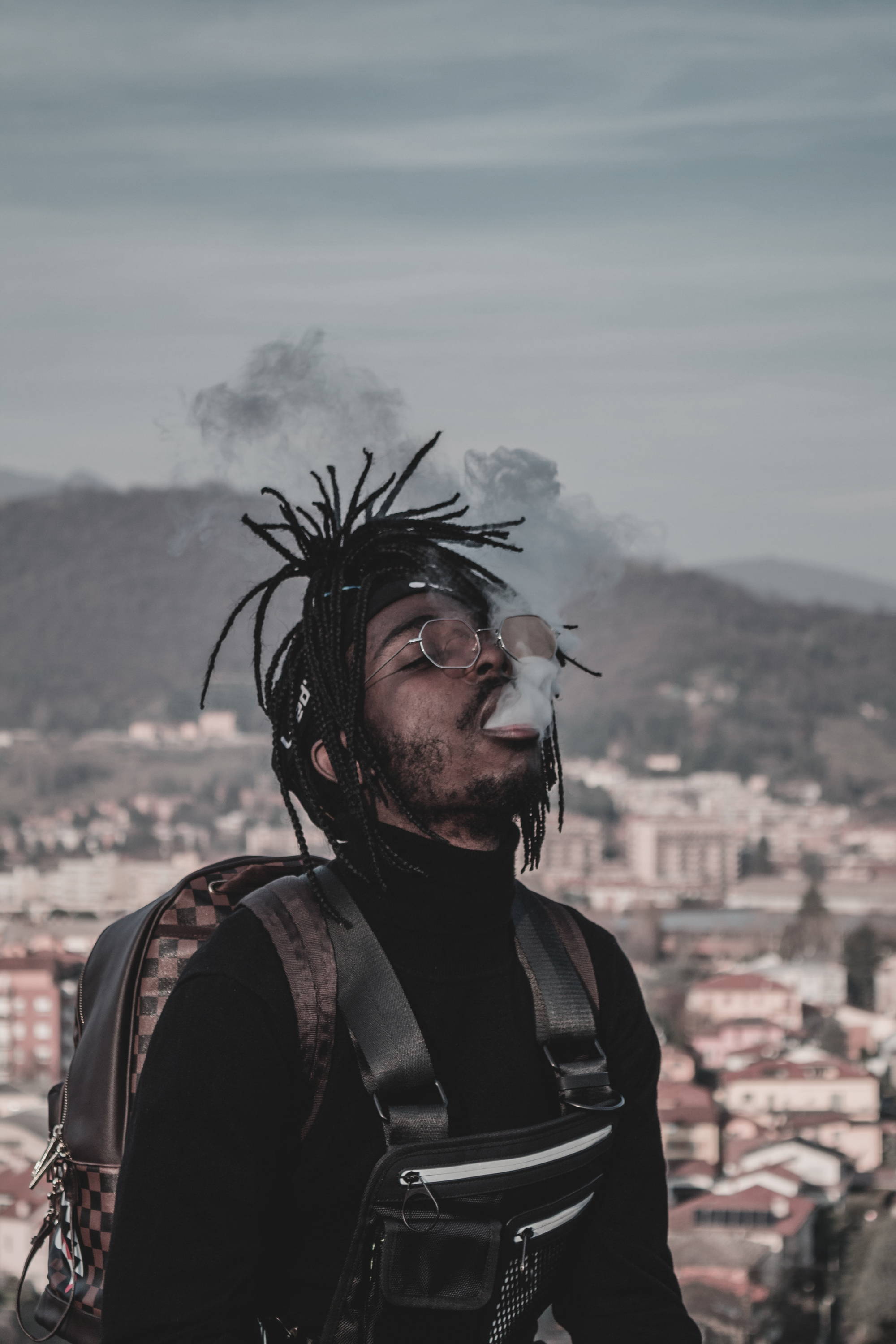 A man wearing a backpack enjoying smoking from a delta 10 vape