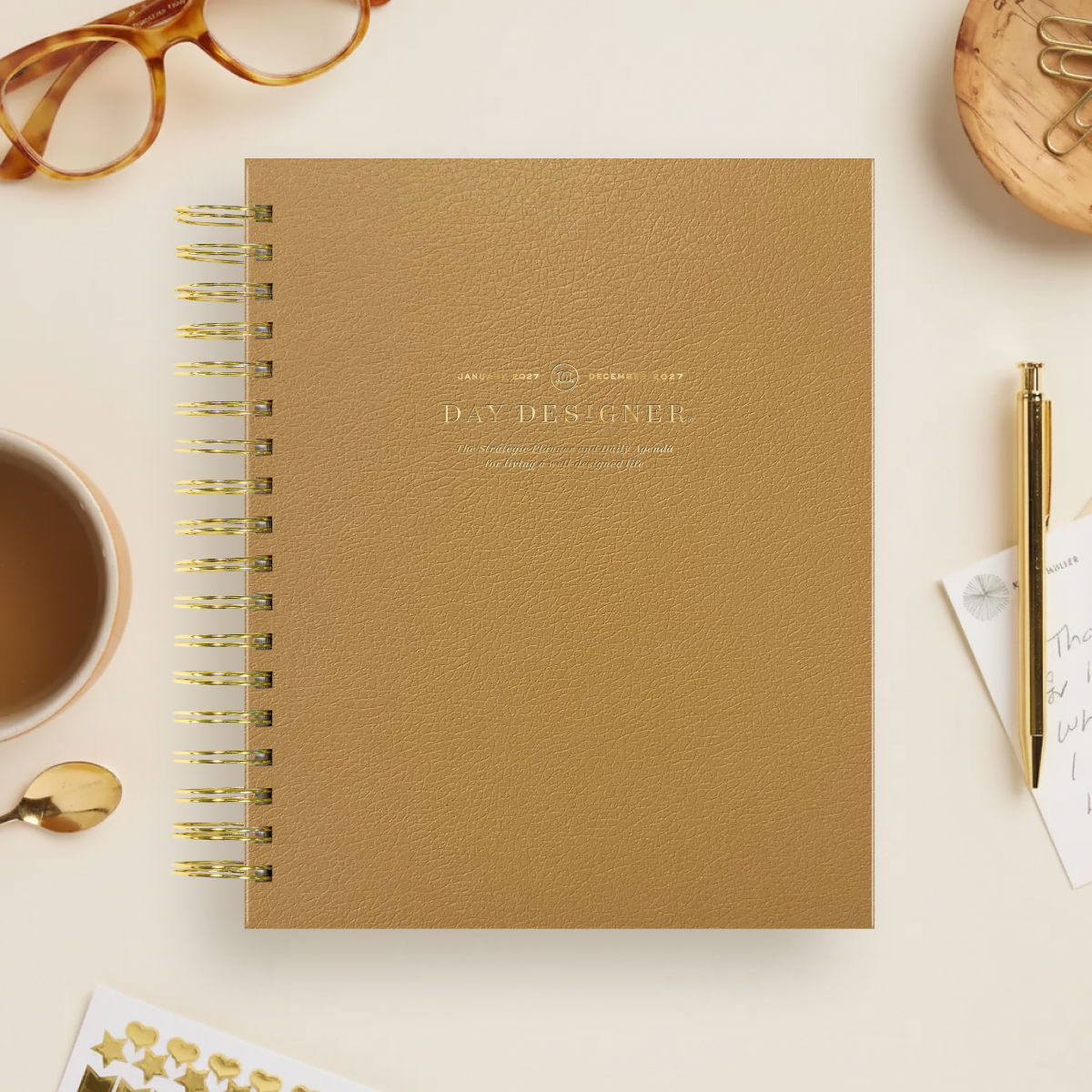 2027 day designer planner featuring caramel coloring, gold binding on beige background