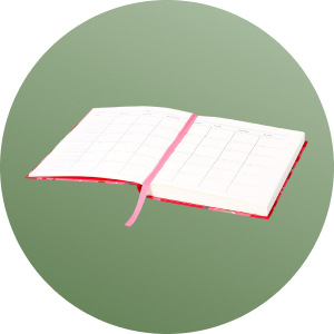 Open planner with a pink ribbon bookmark on a green background.