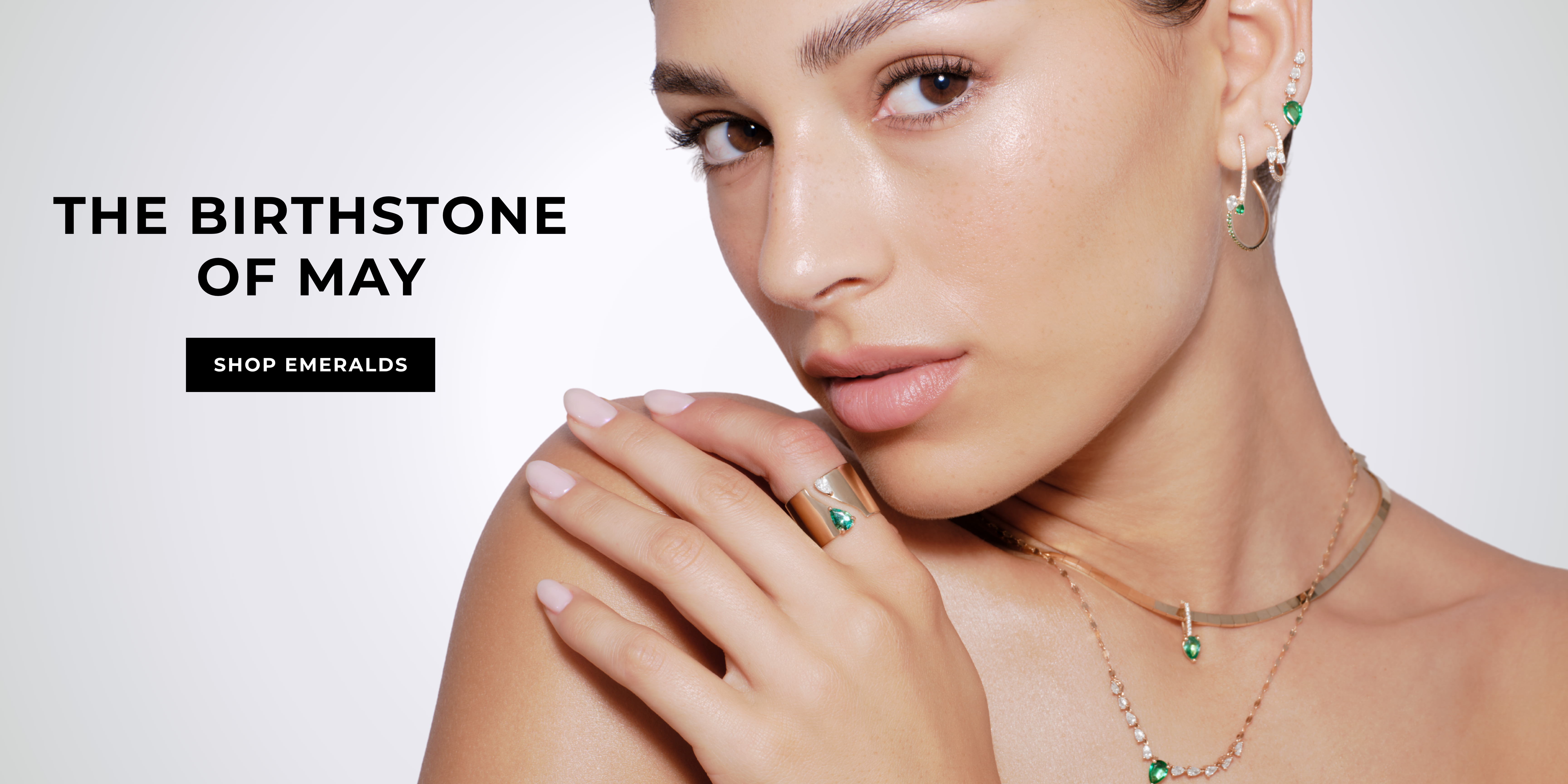 A woman showcasing May's birthstone jewelry.