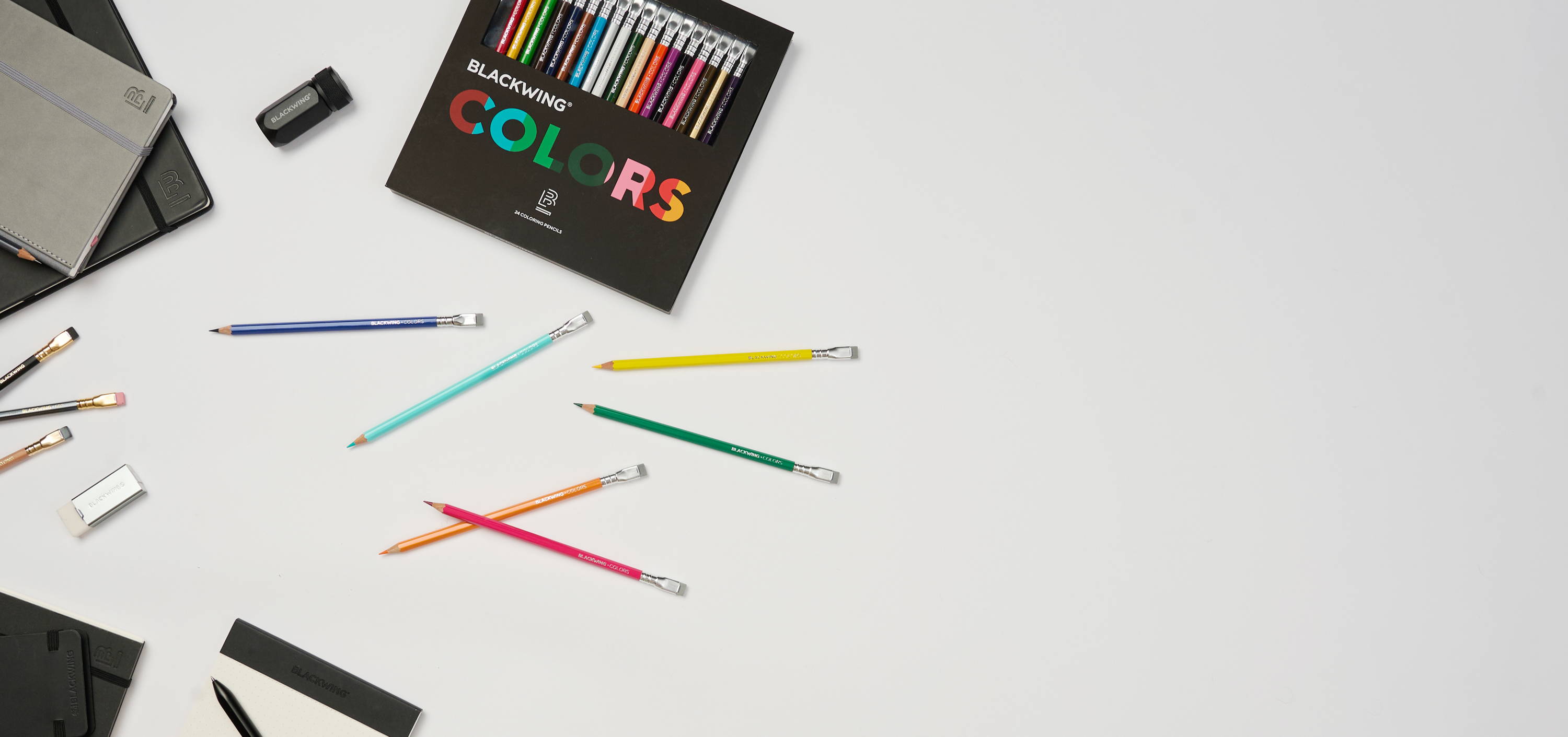 Blackwing Colors 24-pack pencils packing and pencils displayed on a white background next to Blackwing paper products, pencils, and accessories.