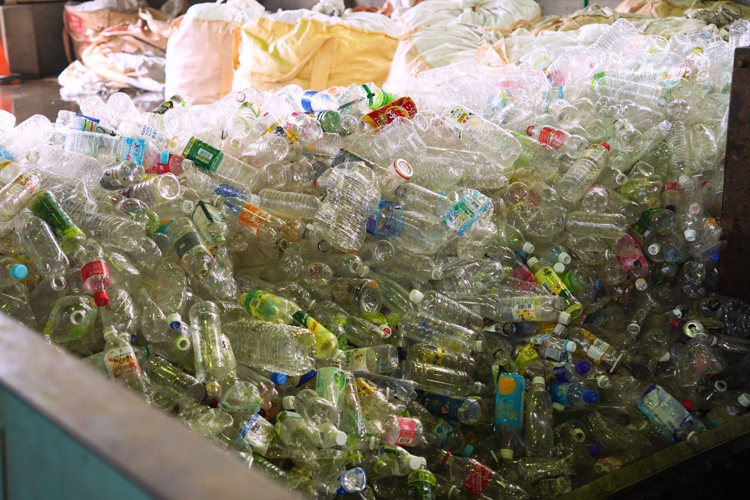 A pile of plastic bottles in a recycling facility.