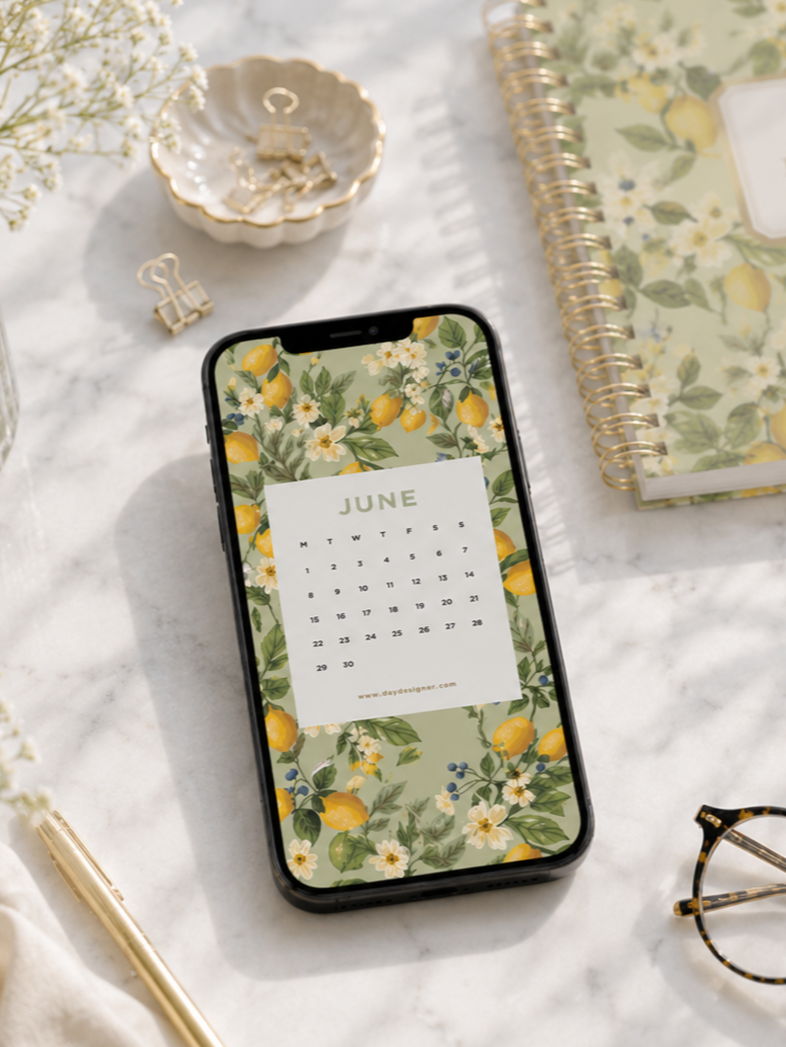 mobile device with june digital wallpaper and lemon floral background, white background, day designer planner, dish with paperclips, glasses, gold pen, white flowers
