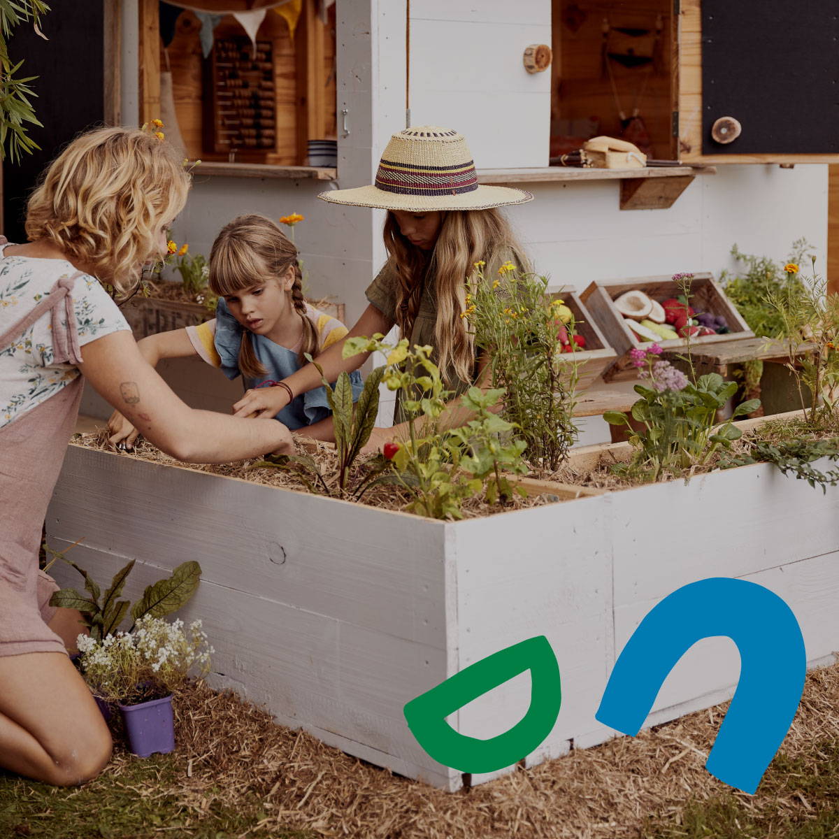Children planting seed in the white garden box