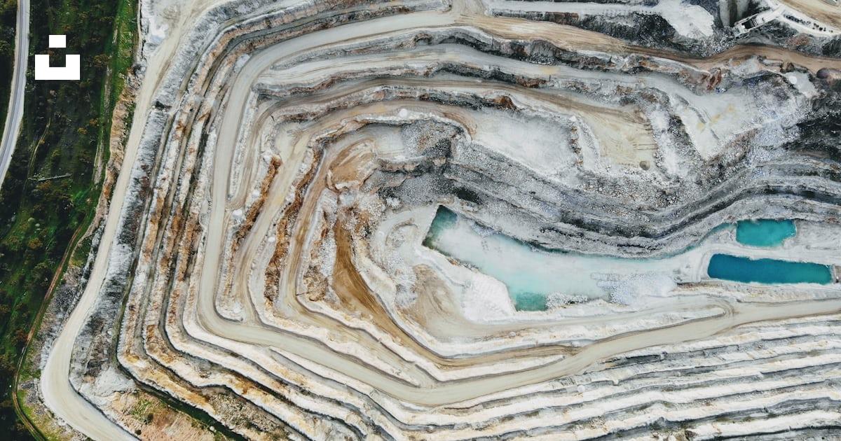 DJI drone aerial view of a terraced quarry showing access roads, benches and changing site conditions