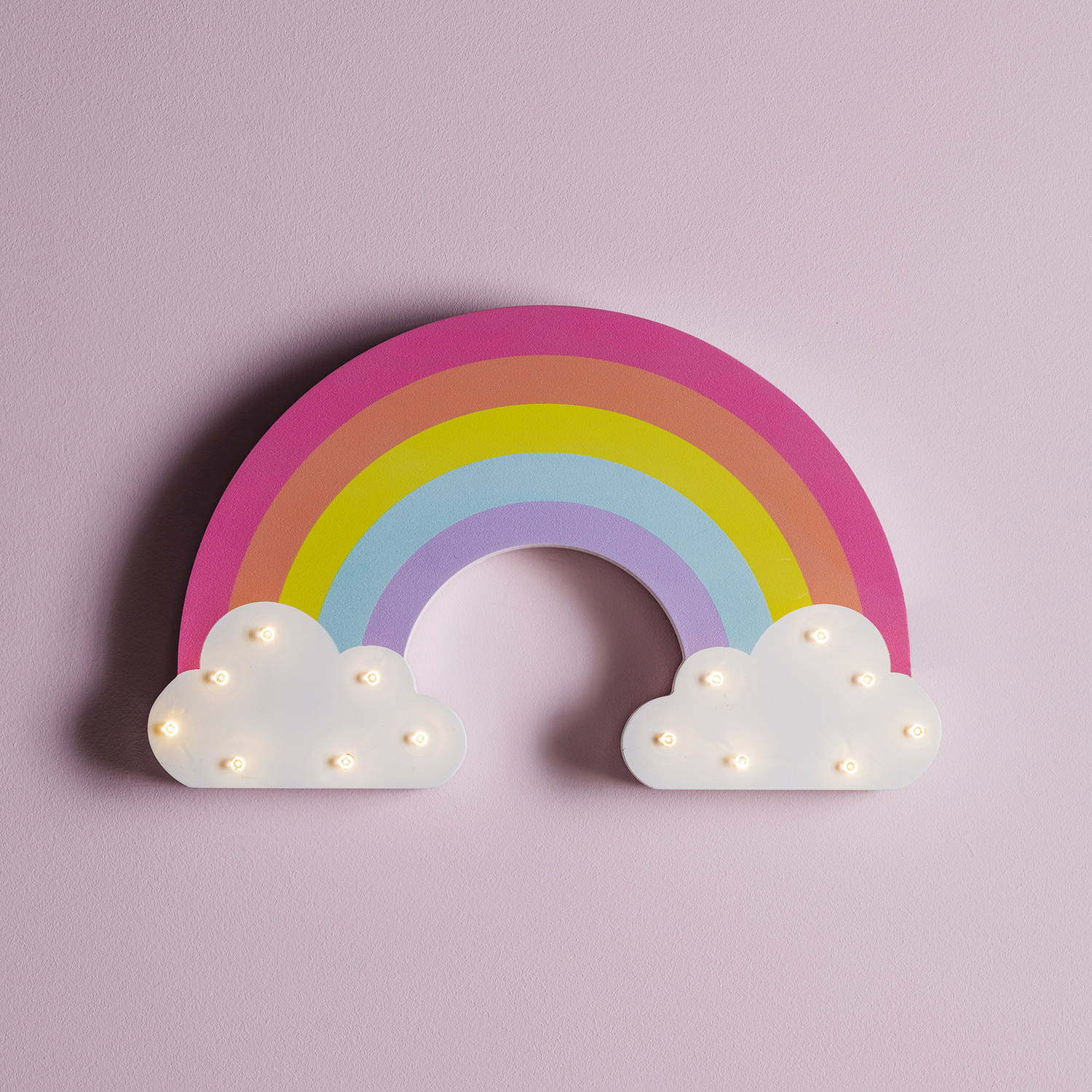 A rainbow wall light with LEDs on the clouds against a pink wall.