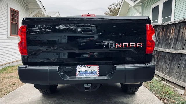 Rear view black Tundra American flag TUNDRA tailgate decal HornBlasters license plate frame Texas plate driveway Stephen's 244 Spare Tire Delete gallery photo 4