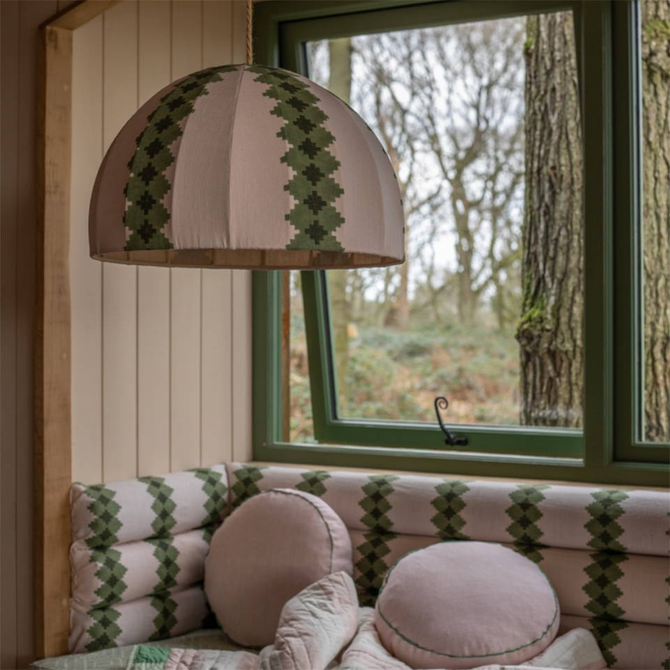 The inside of a treehouse in the UK filled with The Campbell Collection pink and green soft furnishings.