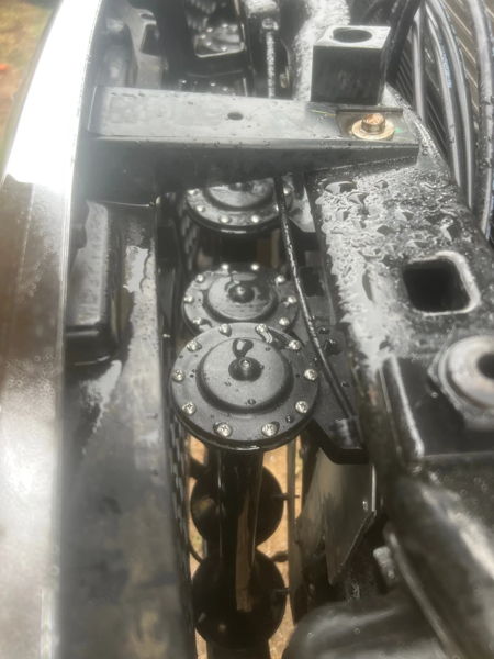 Top-down view of three black circular horn assemblies mounted vertically behind front grille