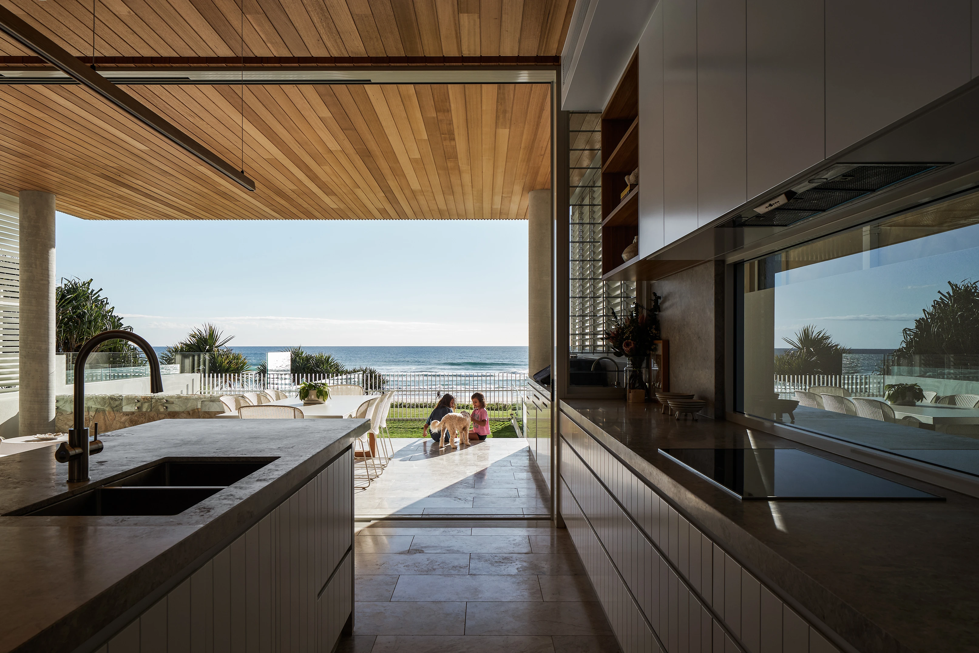 Timber linear pendant light in a modern kitchen with ocean view