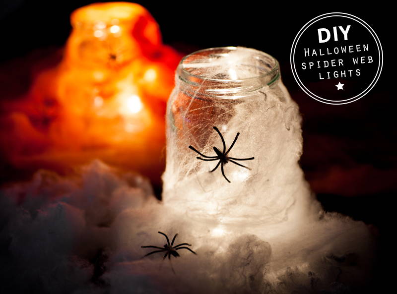 Mason jar with cobwebs and fake spiders with LED lights inside.