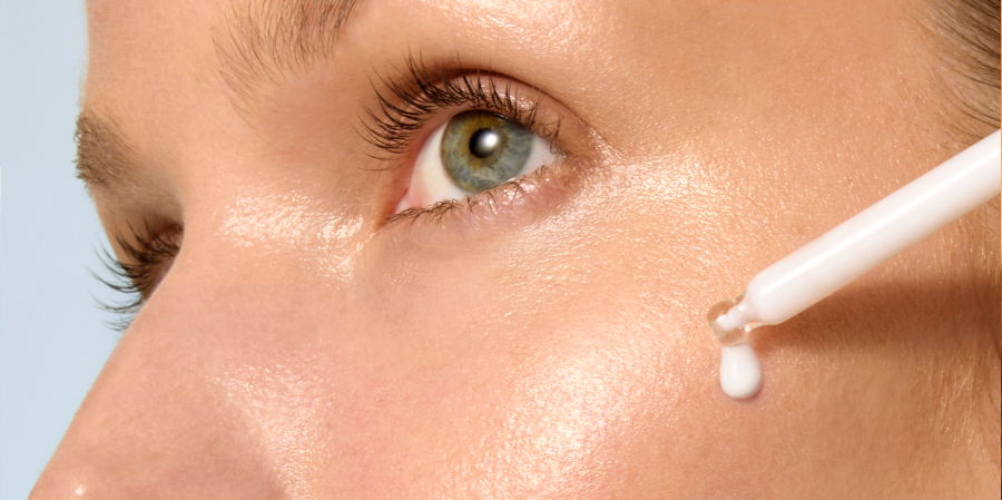 Close-up of a person applying cream near their eye.
