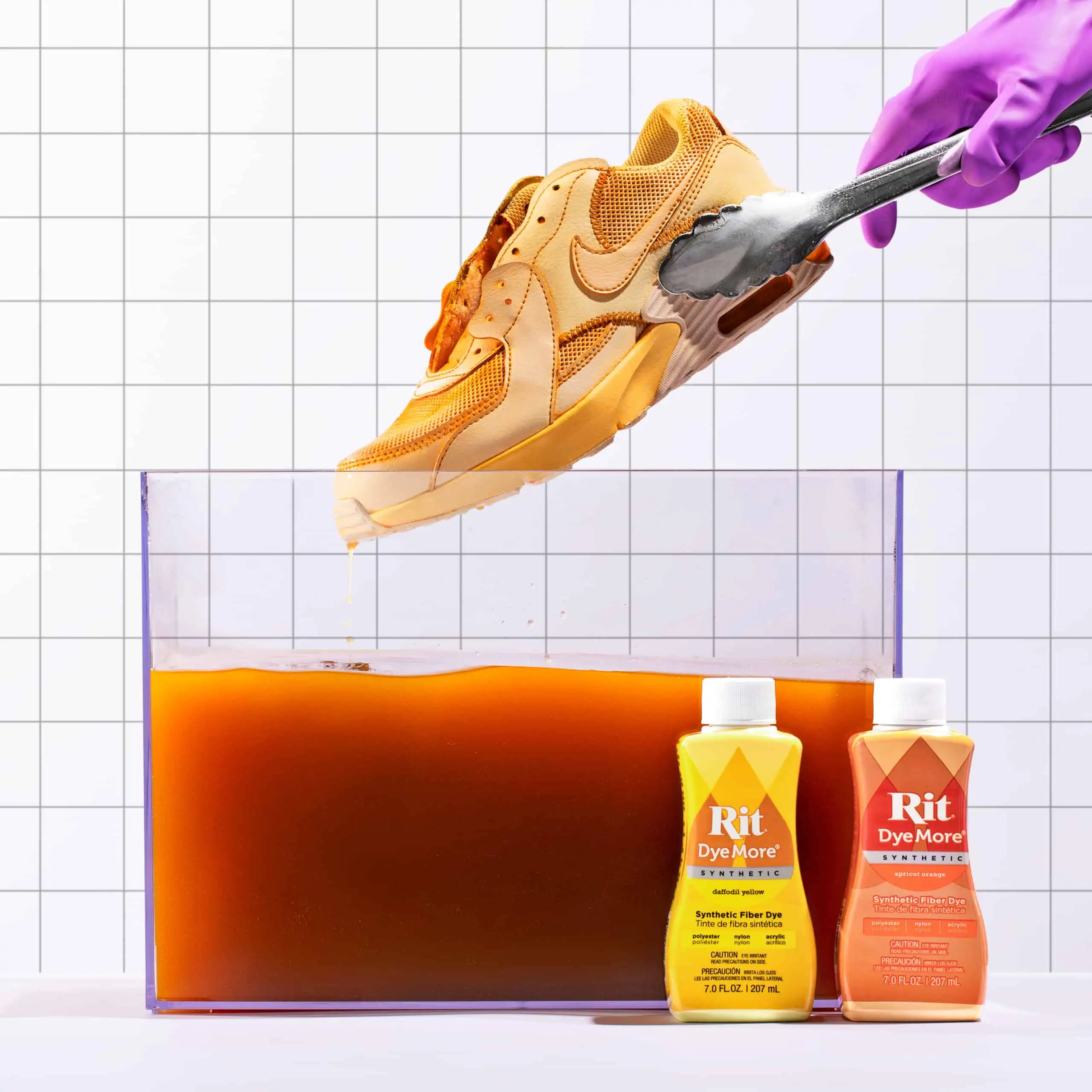 A shoe being cleaned in a container with cleaning products beside it.