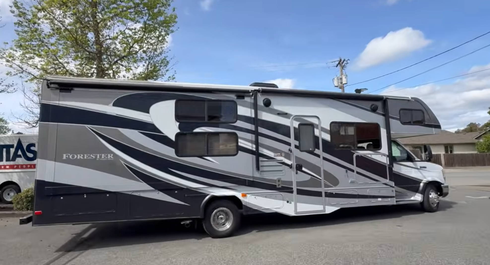 A parked RV with a sleek design against a clear sky.