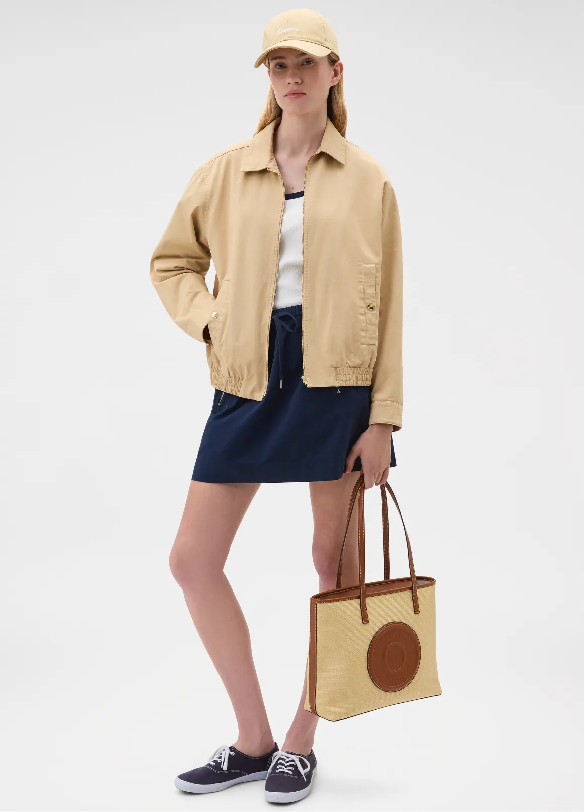 Young woman in casual outfit holding a tote bag.