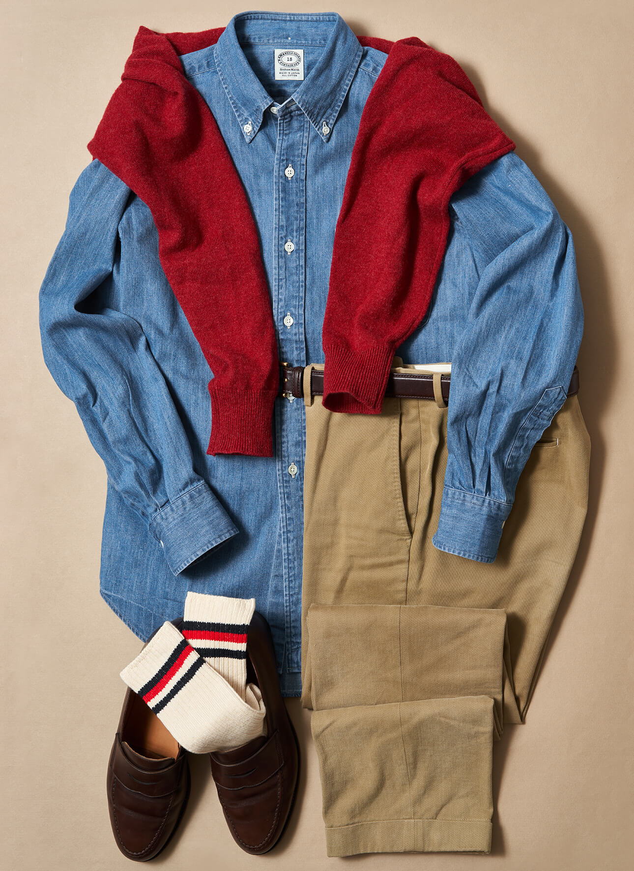 Casual outfit with a blue shirt, red sweater, khaki pants, and loafers.