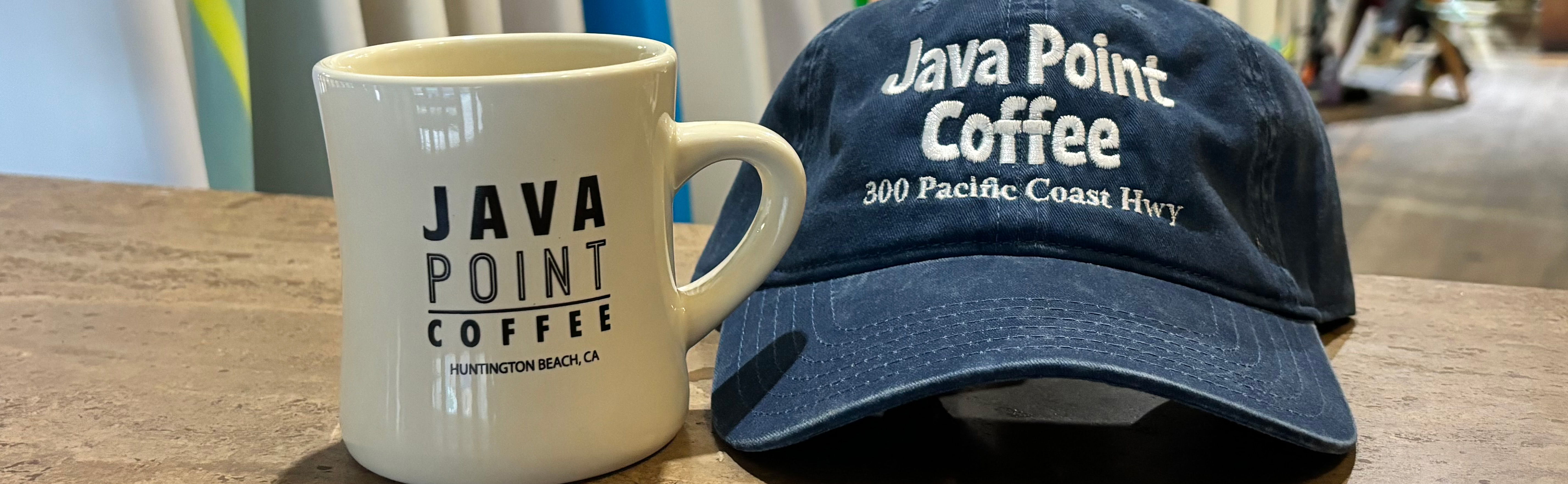 picture of coffee mug and hat with surfboards in the background