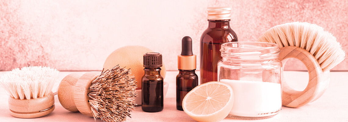 Bottles and brushes for skincare on a soft pink background.