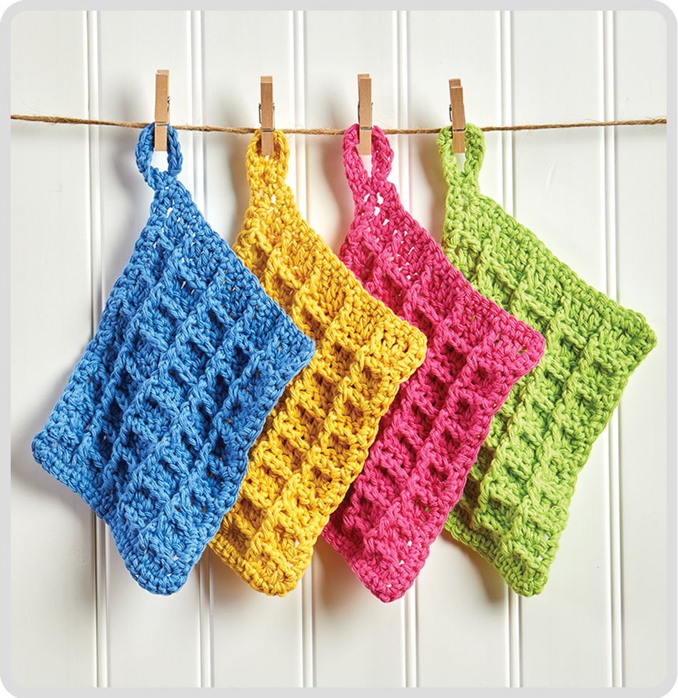 Four colorful crocheted dishcloths hanging on a clothesline.