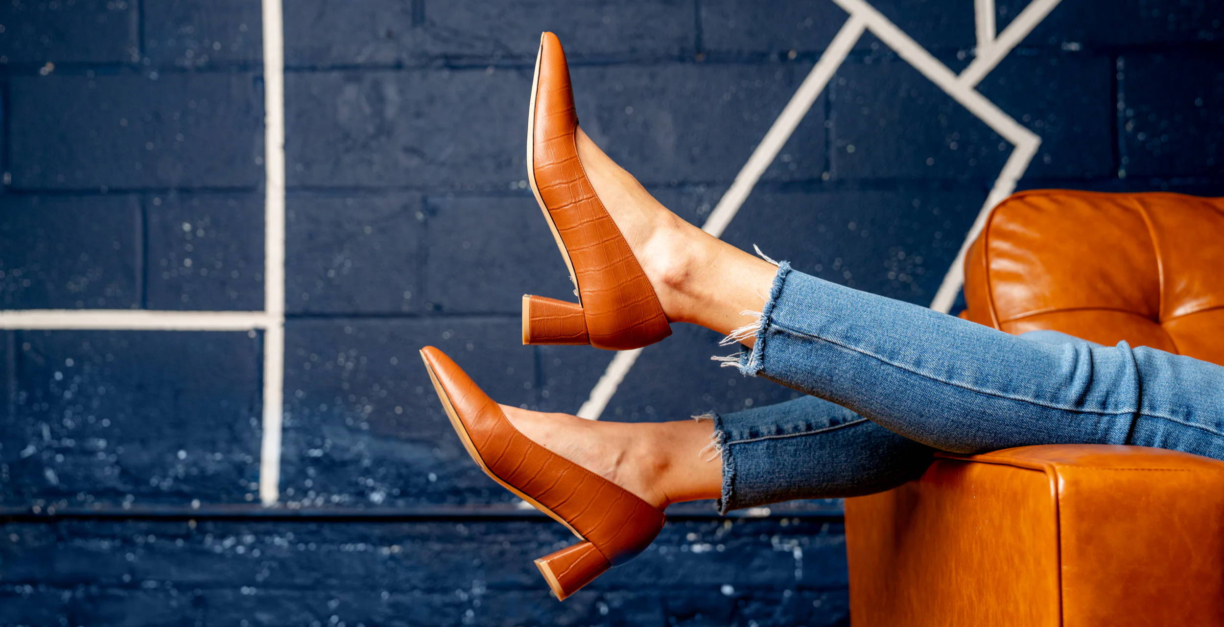 A pair of brown high heels resting on a couch.