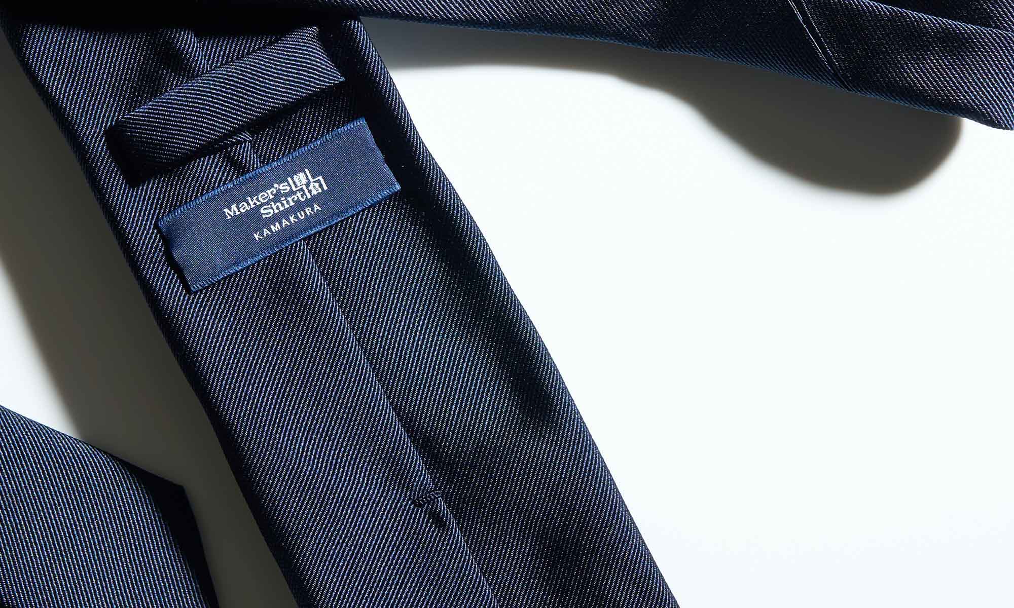 Close-up of a navy tie with a label.