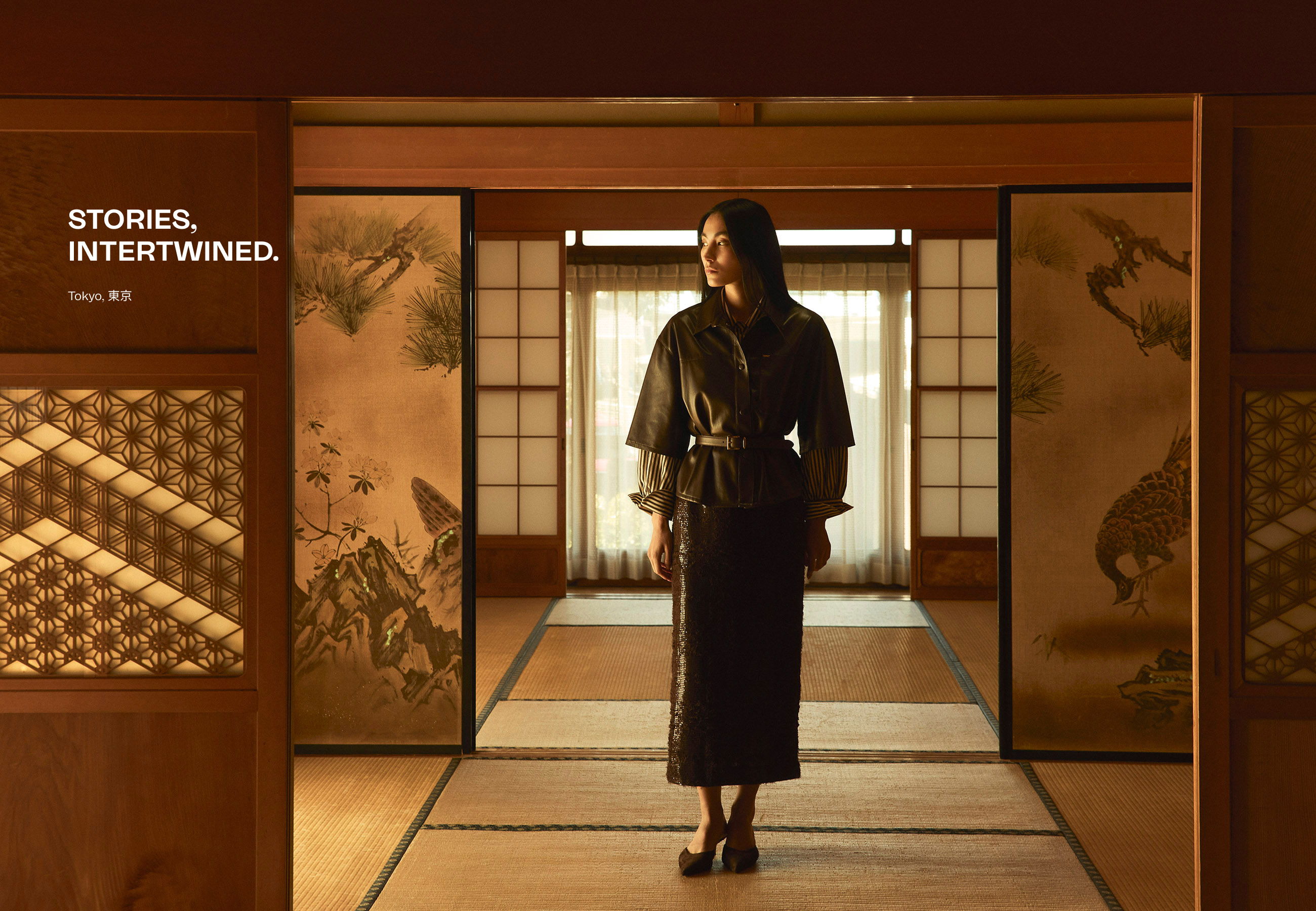 A person in traditional attire stands in a serene, decorated room.