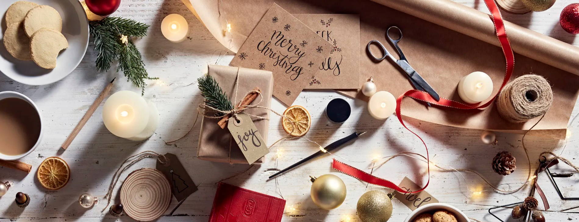 Presents and crafts on a white wooden table with other Christmas decorations.