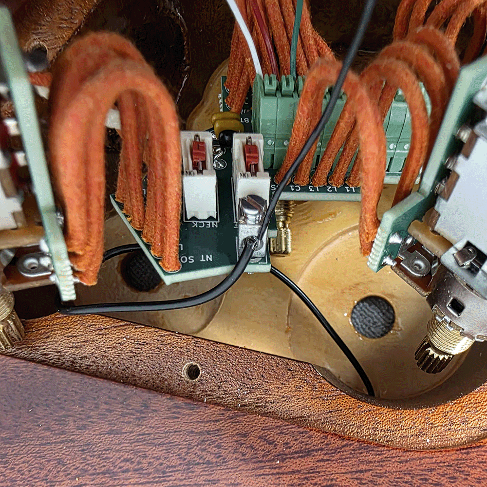 Close-up of electronic components and wiring inside a musical instrument.