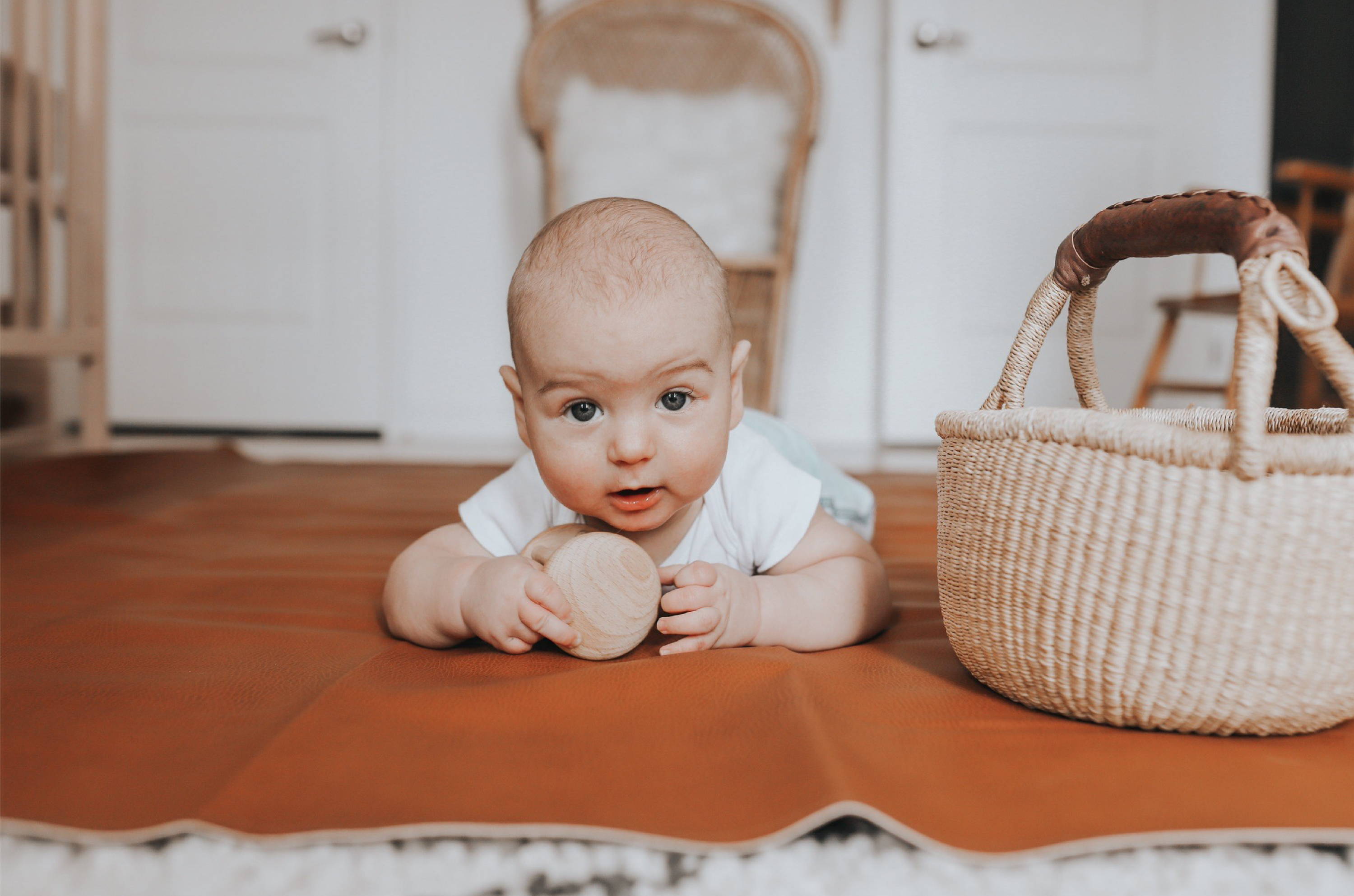 Baby playing on ginger leather mat