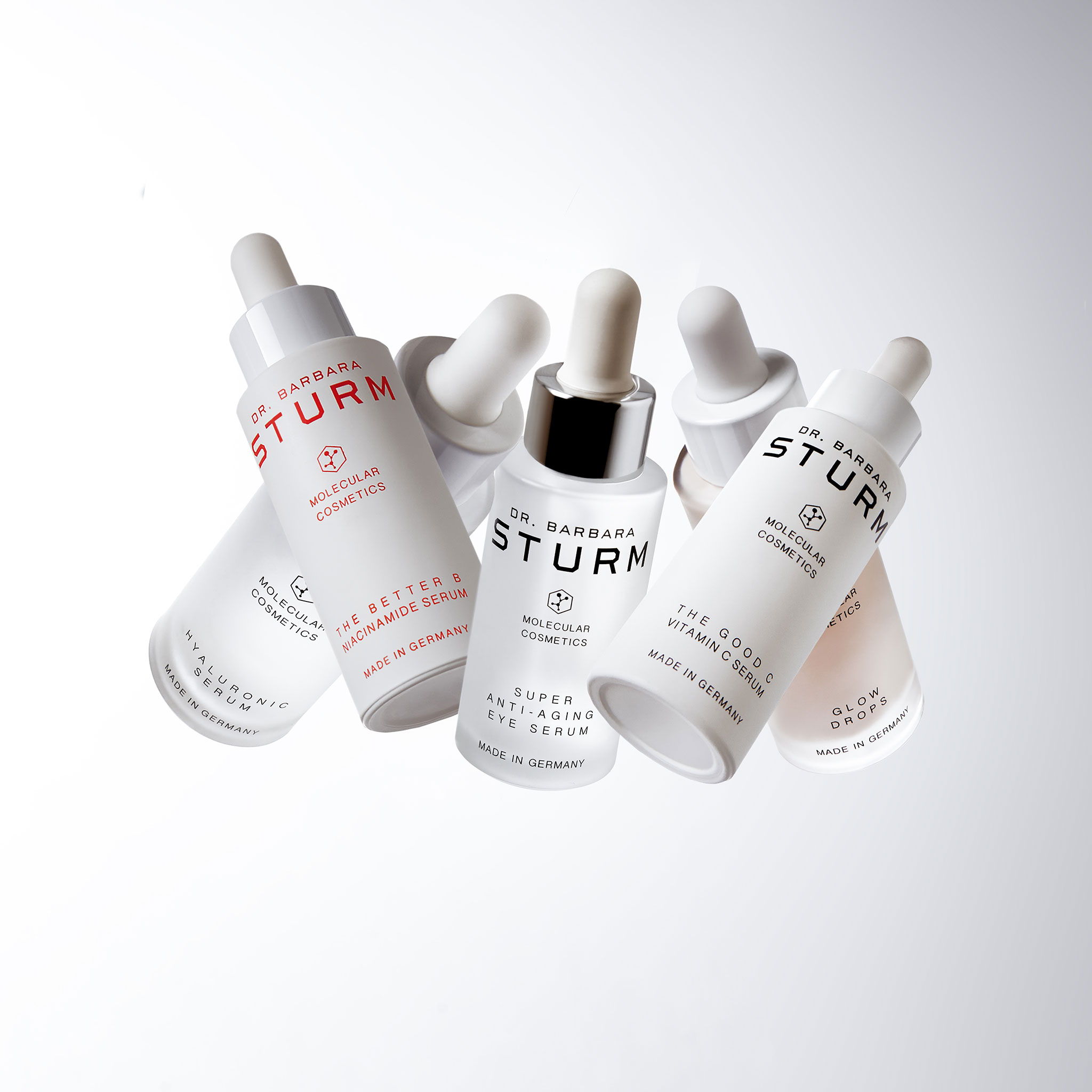 Bottles of skincare serums arranged artistically against a light background.