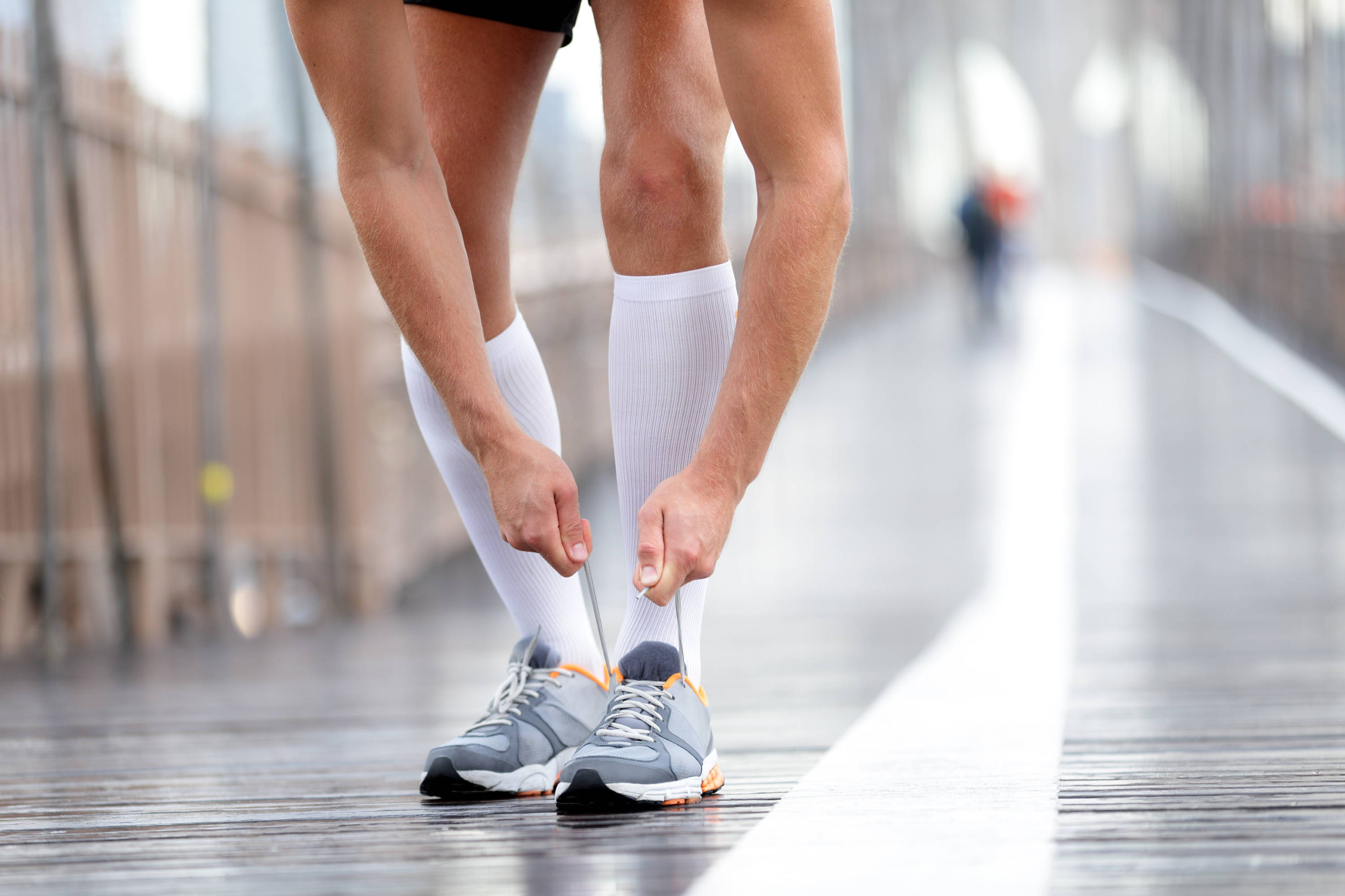 Man tying shoelaces on run, man exercising, Man wearing compression socks