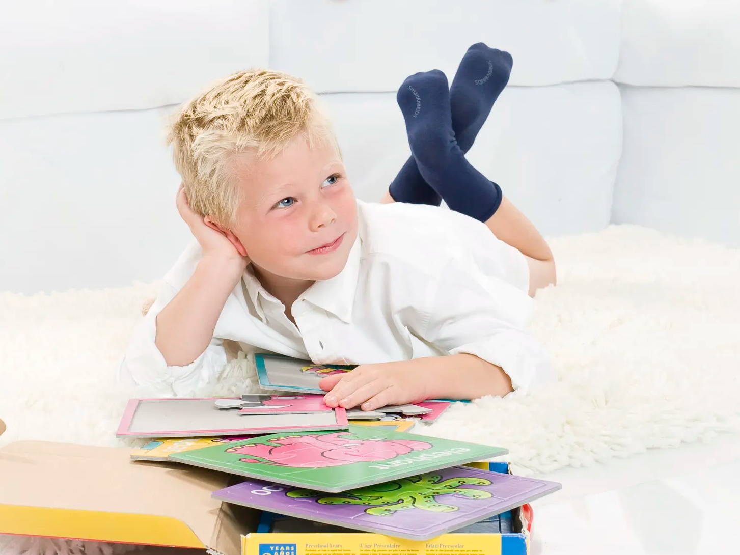 Little boy reading books wearing SmartKnitKIDS Seamless Socks