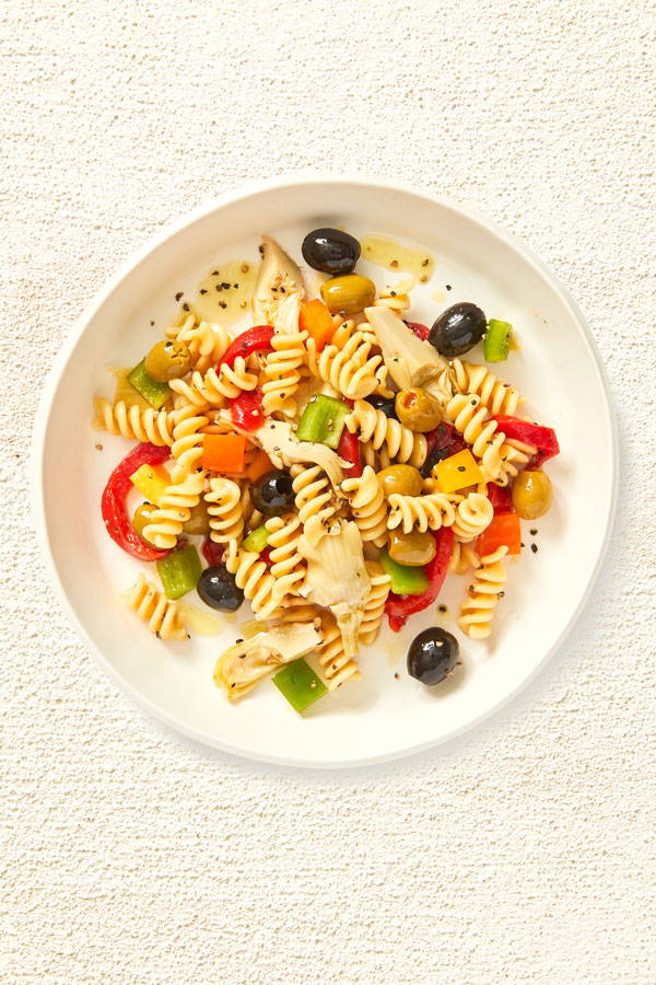 Fusilli pasta salad with olives, bell peppers and artichoke hearts