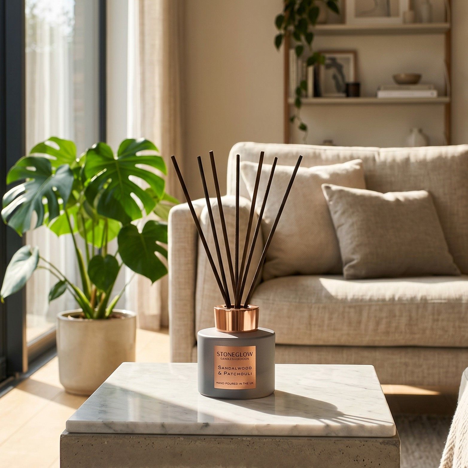 A cozy living room with a diffuser and a potted plant on a table.