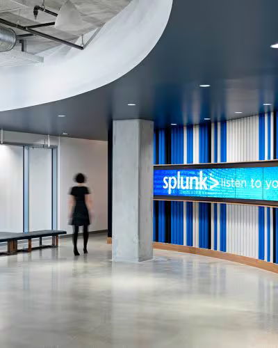 Modern office lobby with Splunk branding and a person walking by.