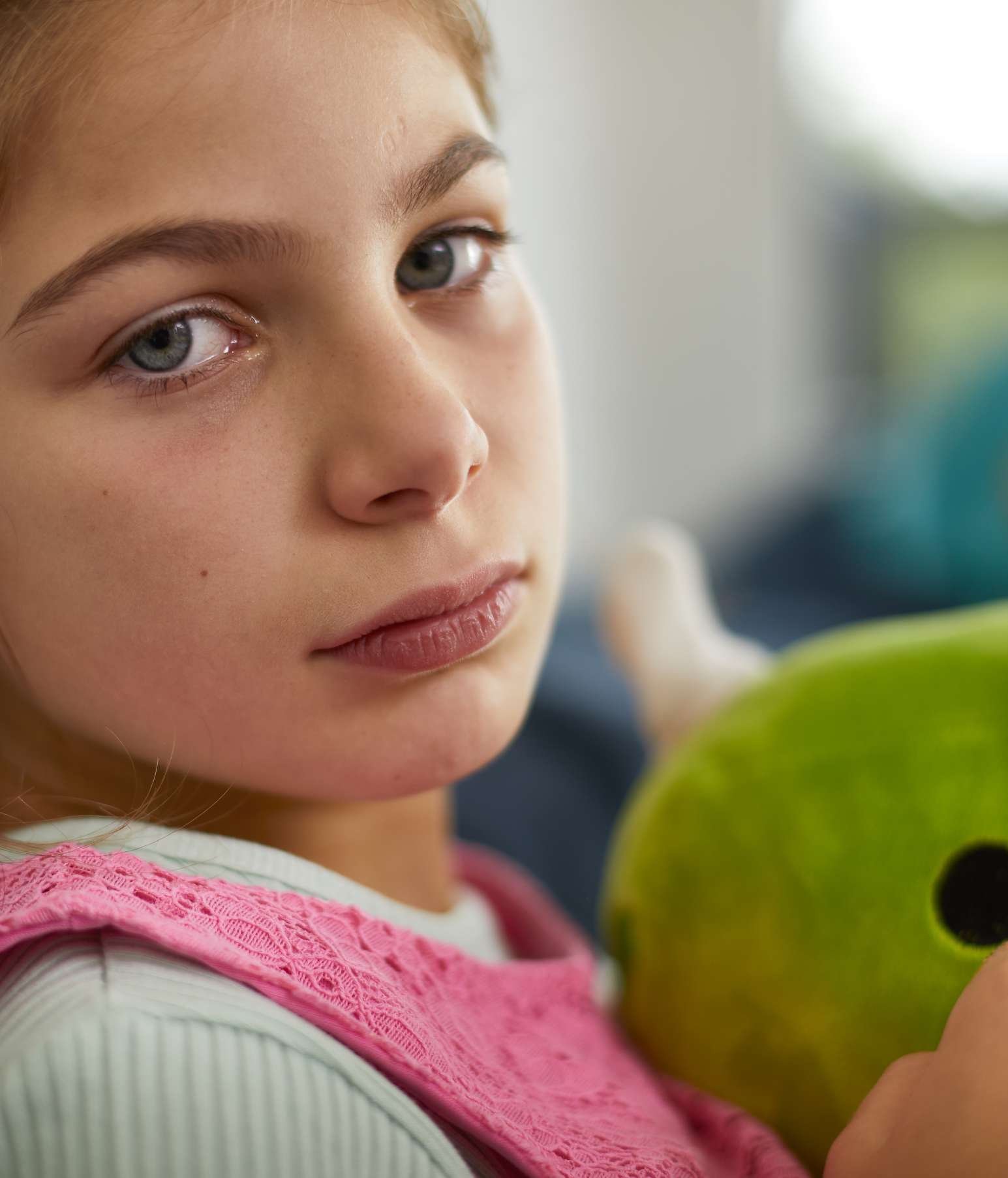 Child looking unwell and hugging her stuffed toy – she has dark circles under her eyes, an allergy symptom, and no fever