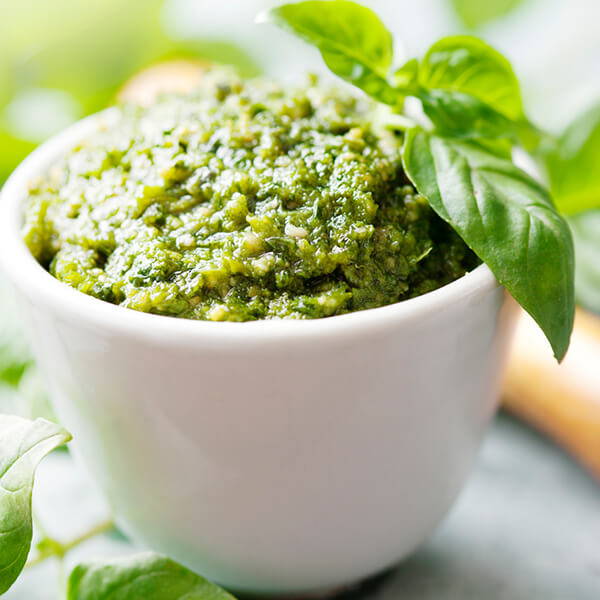 High Quality Organics Express fresh pesto in bowl with basil