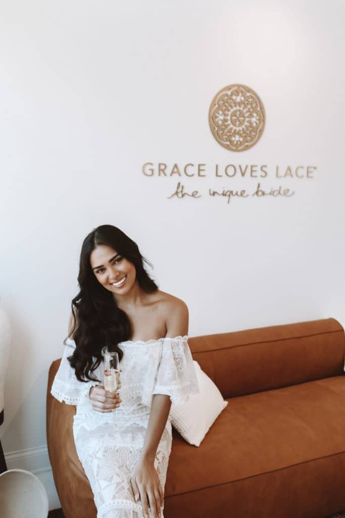 Sala de exposiciones de Grace Loves Lace con la novia llevando el vestido de novia Emanuela