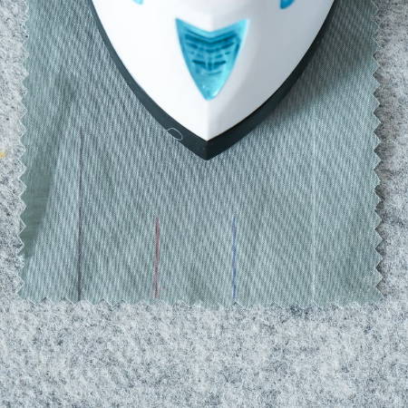 removing the marks drawn with a heat erasable fabric marker from fabric with a hot iron