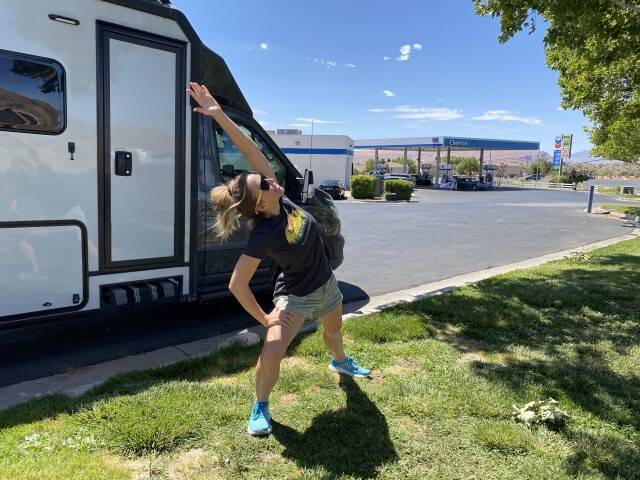Stefany stretching outside their RV at a rest stop.