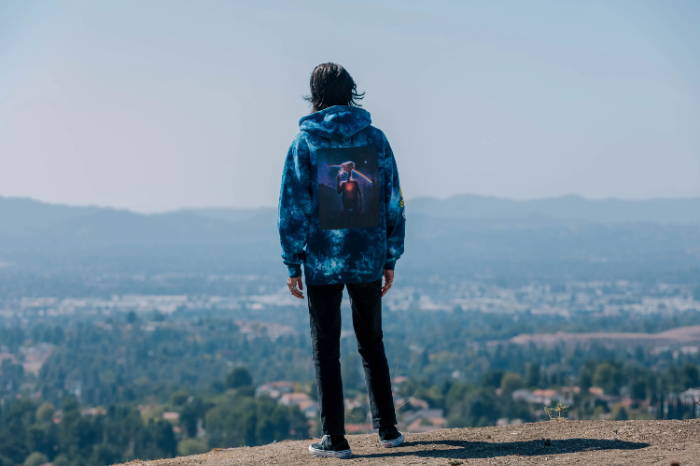 male model in blue galaxy shoe palace x et hoodie looking out from a viewpoint