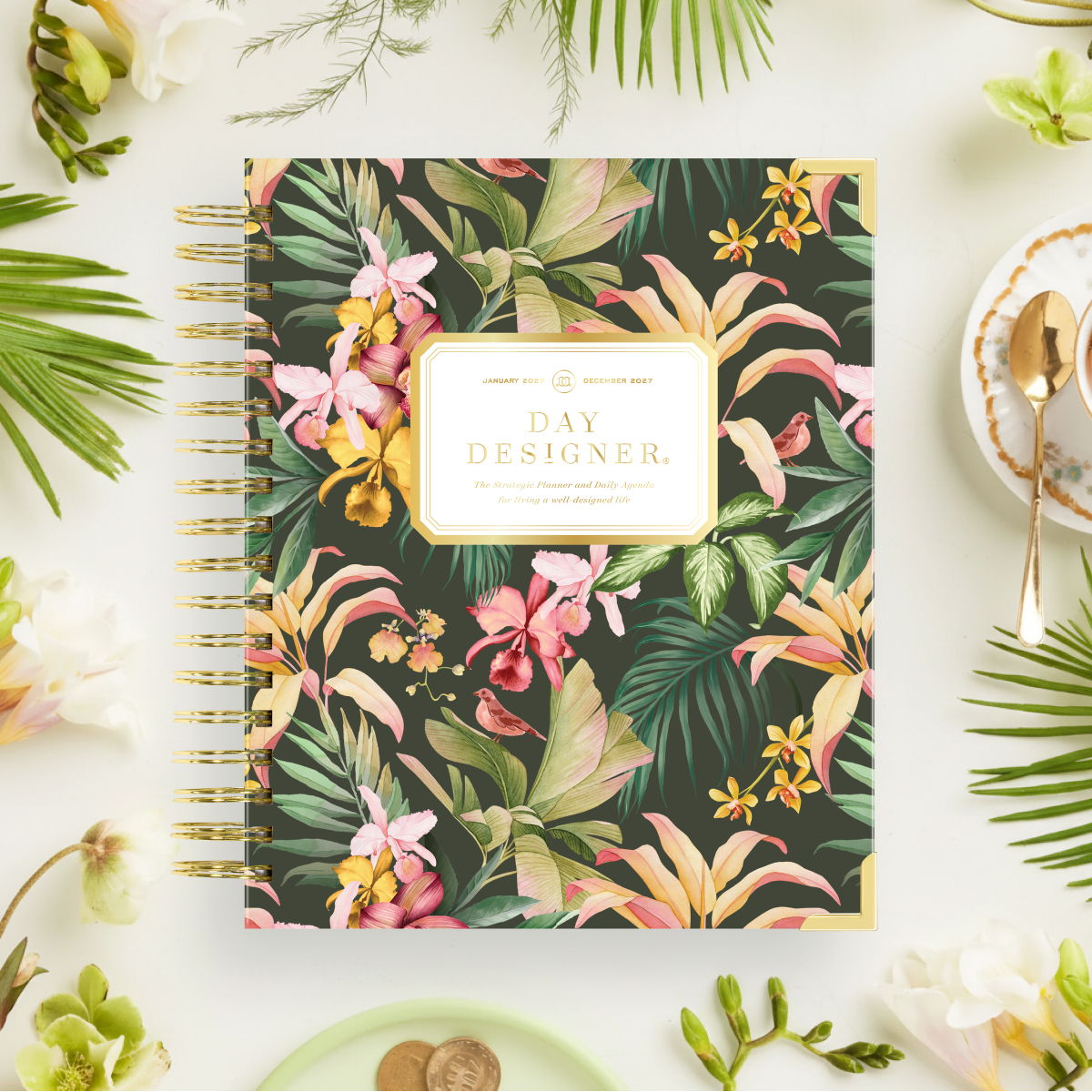 2027 day designer planner featuring tropical flowers, palm leaves on a green background