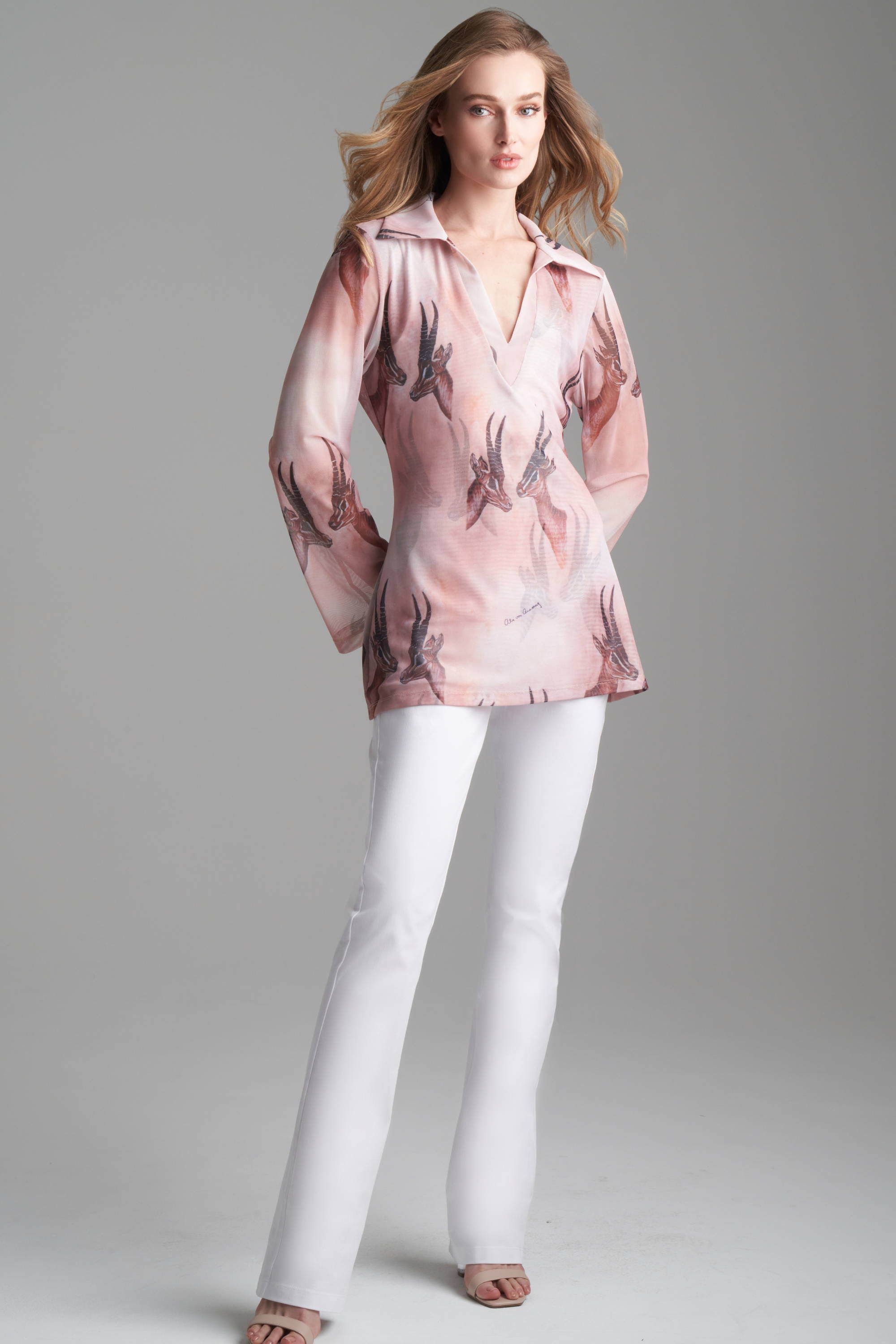 Woman wearing horn printed mesh shirt with white stretch cotton pants by Ala von Auersperg