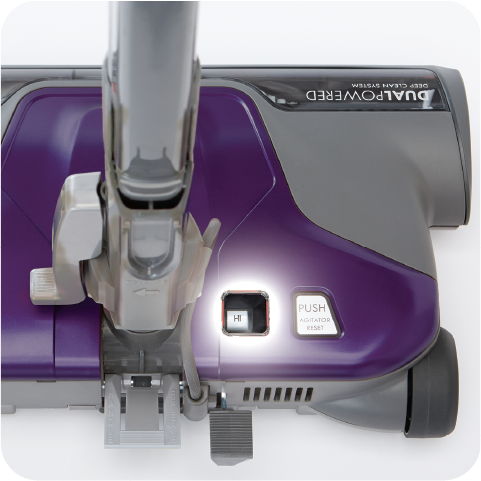 Purple vacuum cleaner with a handle and a light feature.